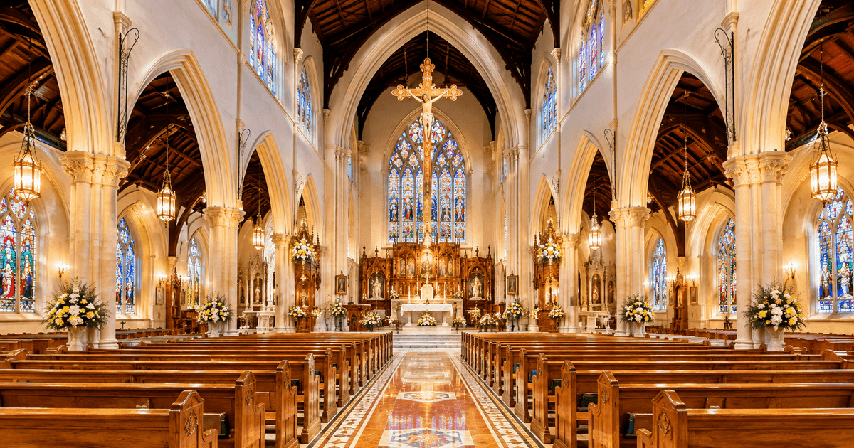 Beautiful church interior with Gothic arches, stained glass windows, wooden pews, ornate altar and a large crucifix