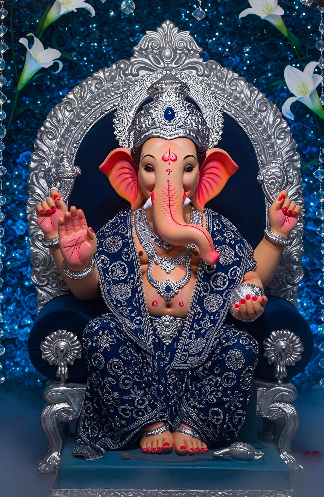 Lord Ganesha seated on silver throne wearing royal blue attire with silver ornaments