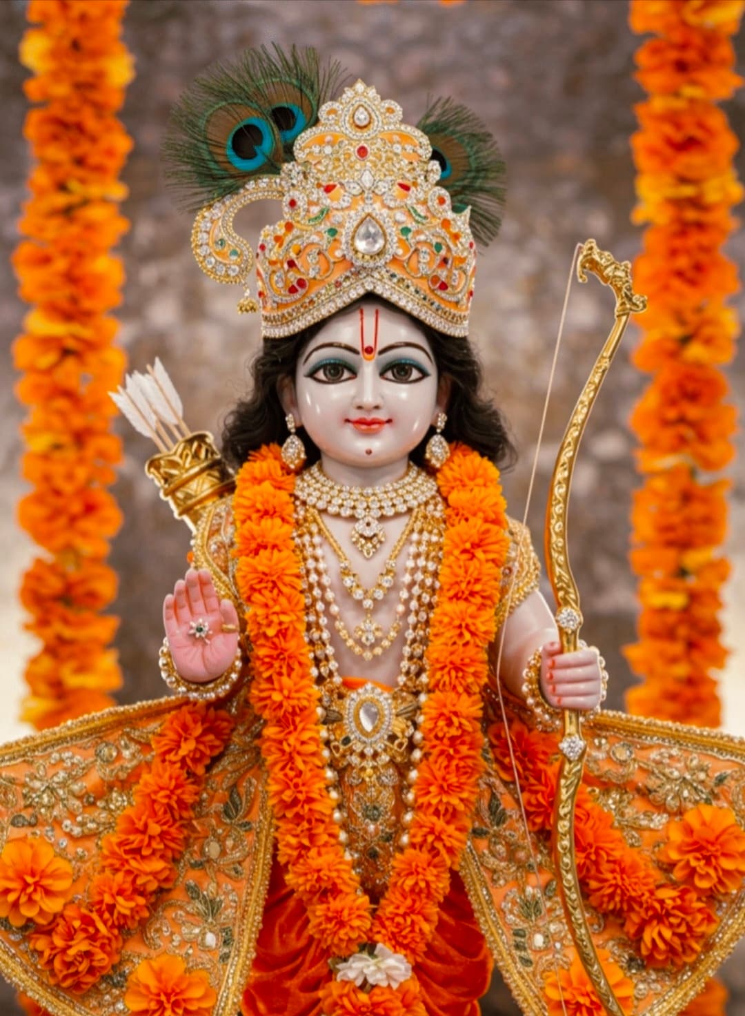 Idol of Lord Rama with golden crown, orange garland, and bow.