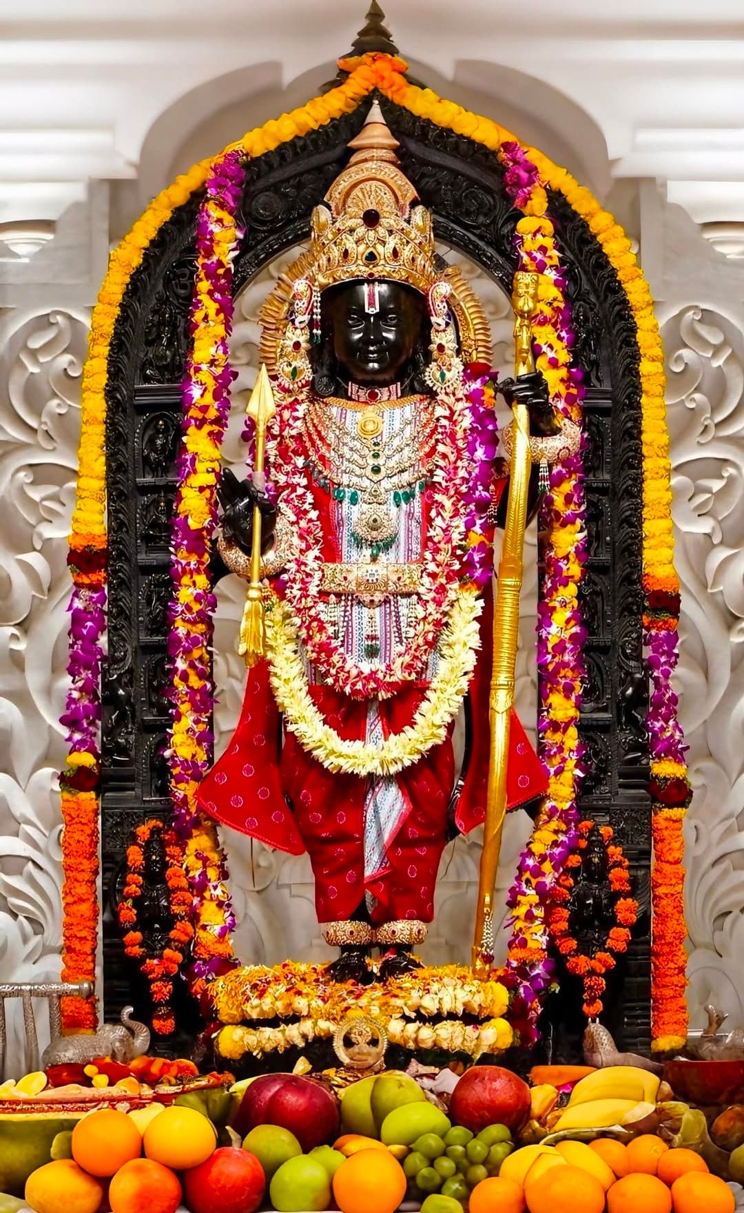 Lord Vitthal idol adorned with garlands, ornaments, and offerings in temple.